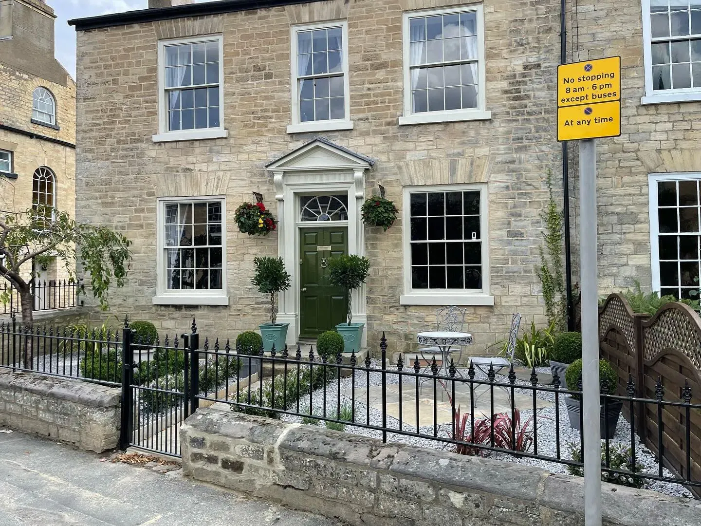 A brick building with a green door and window.